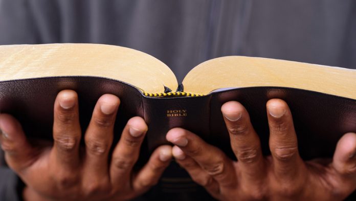 A Man Hands Holding The Holy Bible
